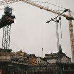 En takläggare arbetar på ett äldre tak i centrala Stockholm där bebyggelsetätheten ställer höga krav på planering och logistik.